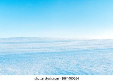 White snowy fields under a blue sky. Winter landscape.