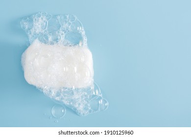 White Soap Bar And Foam On Pastel Blue Background. Bar Of Soap With Bubbles. Flat Lay, Top View, Copy Space