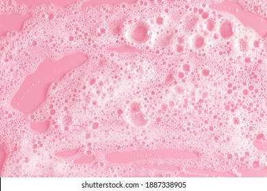 White soap foam on pastel pink background. Flat lay, top view, copy space