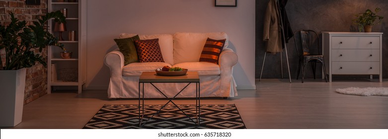 White Sofa, Small Table And Chest Of Drawers In Dark Living Room