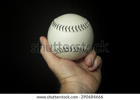 White softball in hand ready to throw.
