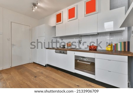 White spacious kitchen with lacquer coating and paintings on the walls