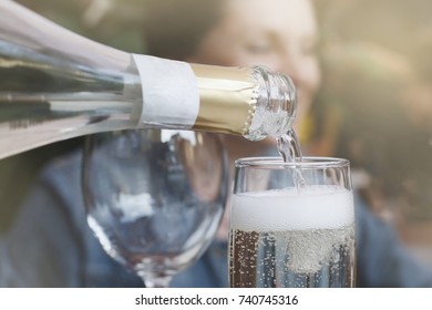 White Sparkling Wine Poured From A Bottle Into A Glass