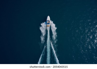 White speed boat fast movement on the water top view. Travel - image. Top view of a white high-speed boat. Boat movement on blue water top view.