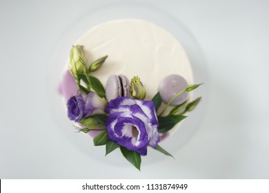 White Sponge Cake With Violet Flowers On A White Background