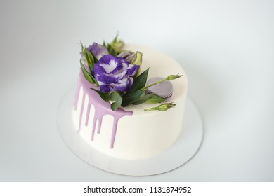 White Sponge Cake With Violet Flowers On A White Background