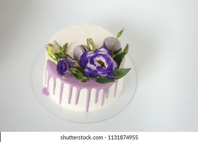 White Sponge Cake With Violet Flowers On A White Background