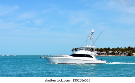 A White Sport Fishing Yacht Passing Sunset Key In Key West Harbor On The Way To The Atlantic Ocean To Go Fishing.
