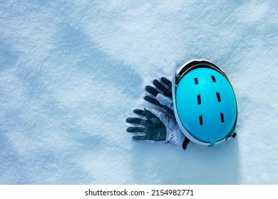 White Sport Gloves In The Snow With Blue Ski Helmet And Mask, Clean View From Above, Winter Holidays Concept