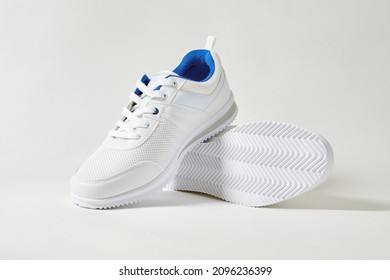 White Sports Sneakers With Shoelace On White Wall Background. Man Sneakers For Fitness. White Sneaker With Leather Accents.