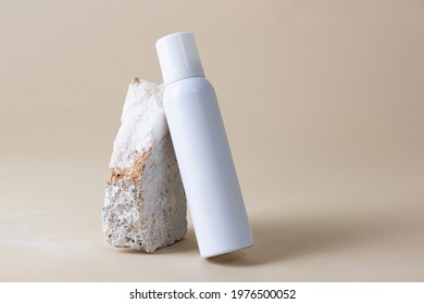 White spray bottle against a rock 