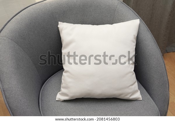 White square canvas\
pillow mockup on grey armchair, small cotton cushion mockup in\
living room interior.	