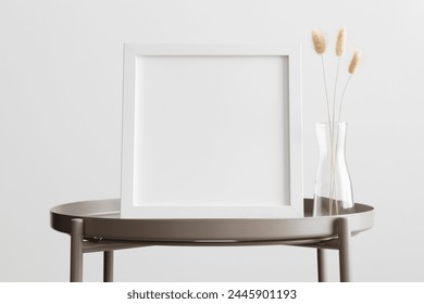 White square frame mockup with a lagurus decoration on the beige table.