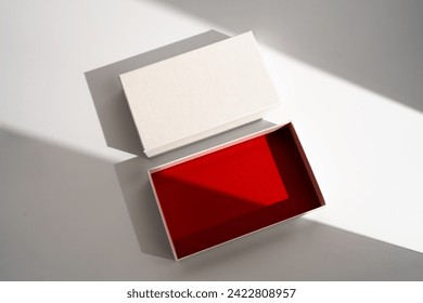 White square gift box mockup on white background, harsh shadows, red inside. From above, top view, minimalist concept, mock up, luxury