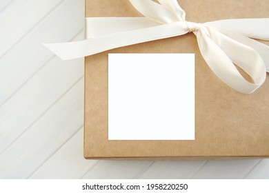 White Square Gift Sticker Mockup On Gift Box With White Ribbon, Adhesive Label For Design Presentation.	