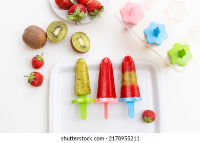 White square plate with colorful homemade kiwi and strawberry ice cream, on a white table - Shutterstock ID 2178955211