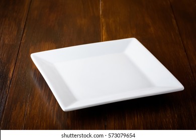 White Square Plate On A Wooden Table