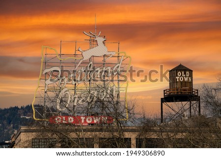 White Stag Portland Oregon old town sign at sunset with jumping deer.  Also water tower old town sign.