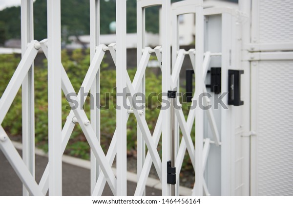 White stainless\
steel Barrier Gate or folding fence gate for protection in external\
traffic that blocks the\
road.