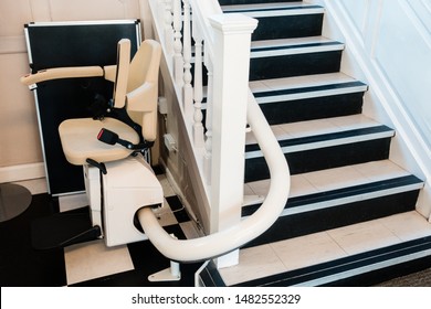 White Stairlift On Staircase For Disabled People And Elderly People Indoor In Home Or School And Office For Free Service.