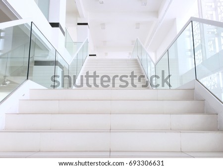 White stairs with steel and glass railing in a new modern building. white stairs going up to holy place