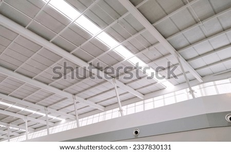 White Steel Roof Beam and Mesh Ceiling Grille with lay light Inside of large Modern Building, low angle and perspective side view