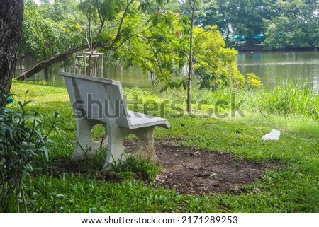 White stone benches were set by the garden pond.