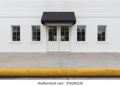 White Storefront Building With Black Awning