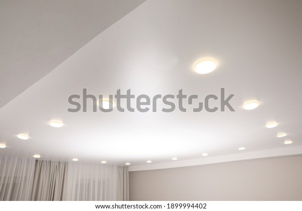 White stretch\
ceiling with spot lights in\
room