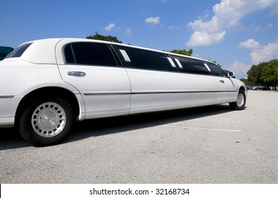 White Stretch Limousine With Partly Cloudy Blue Sky