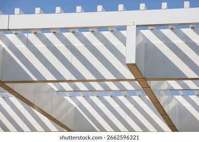 The white structure has a lot of white and brown elements. The white elements are the roof and the beams, while the brown elements are the beams and the roof. The structure is open