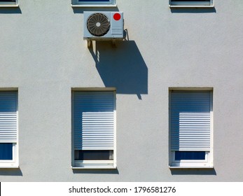 White Stucco Facade Detail. Windows And Air Conditioner Inverter Unit. Exterior Elevation. Flat Frontal View. Bright Light. Roll Down Window Shades. Modern Architecture. Home Ownership. Global Warming