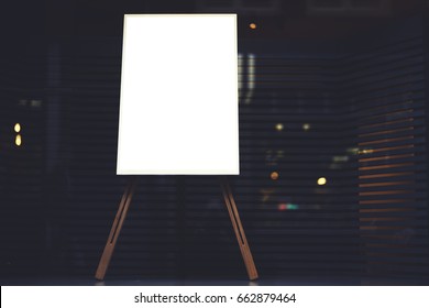 White stylish chalkboard with mock up copy space are for your text message or advertising promotional content, empty presentation wooden board standing on the glass storefront