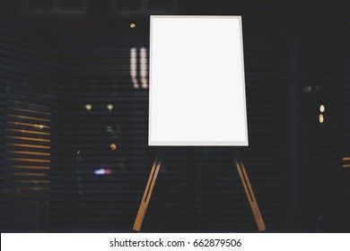 White stylish chalkboard with mock up copy space are for your text message or advertising promotional content, empty presentation wooden board standing on the glass storefront