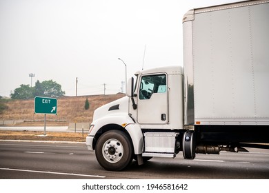 White Stylish Industrial Grade Day Cab Big Rig Semi Truck With Box Trailer Transporting Commercial Cargo Driving On The Unhealthy Road In The Thick Smog From A Disaster Extensive Forest Fire