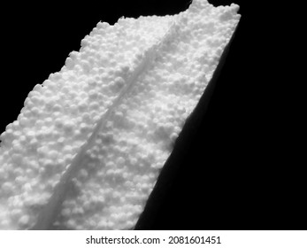 white styrofoam.  two polystyrene foam on a dark background. coarse and porous texture. bearing materials for packaging and other industries