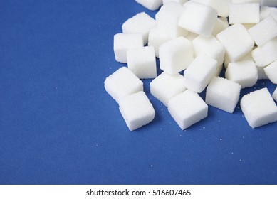 White sugar cubes arranged on a blue background with empty space below - Powered by Shutterstock