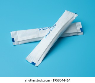 White Sugar Packets On A Blue Background.