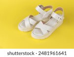 White Summer Sandals on Yellow Background - Fashion Footwear for Women