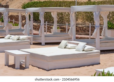 White sun canopy with mattress on luxury sand beach in tropical resort in Red Sea coast in Egypt, Africa. Empty beaches during quarantine - Powered by Shutterstock