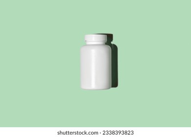 White supplement bottle. Medicine mockup. Blank label vitamin template. Natural organic bio Pills jar. Green studio color background. Clear packaging. Top view, flat lay. Trendy Product presentation