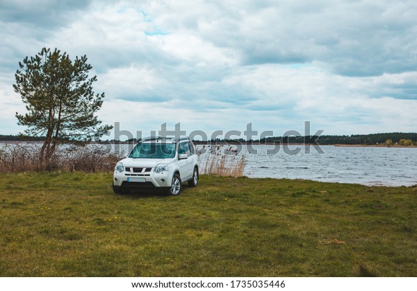 white suv car at\
lake beach overcast\
weather