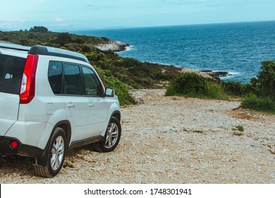 White Suv Car At Rocky Beach Near Sea. Car Travel Concept