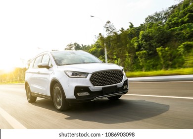 White suv speeding on fast road - Shutterstock ID 1086903098