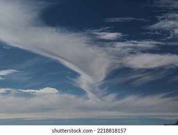 White Swirling Cloud Formation In Blue Sky