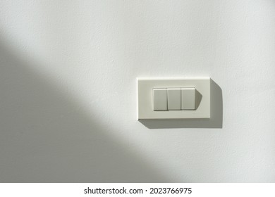 White switch power on a white wall with light and shadow contrast. - Shutterstock ID 2023766975