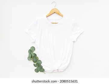 White t shirt on hanger with eucalyptus isolated on white background. Simple white t shirt mock up for your design
 - Powered by Shutterstock