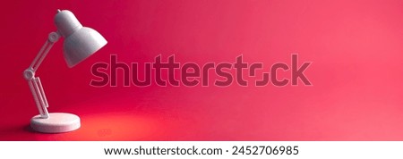 White table lamp on a red background, copy space.
