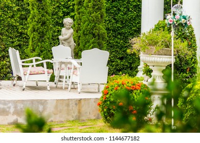 White table set with flower pot and cupid statue decoration on relaxing space in cozy home flower garden on summer. - Powered by Shutterstock