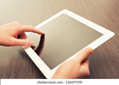 white tablet with a  blank screen in the hands  - Powered by Shutterstock